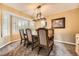 Elegant dining room with bay window, modern chandelier, and view of the kitchen at 11522 Pine Grove Ln, Parker, CO 80138