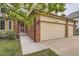 Exterior shot of home featuring brick accents, a two-car garage, and a welcoming entryway at 11522 Pine Grove Ln, Parker, CO 80138