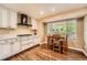 Bright kitchen featuring white cabinets, hardwood floors, and a sunny breakfast nook at 11522 Pine Grove Ln, Parker, CO 80138