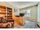Home office with large desk, shelving unit, and a comfortable upholstered chair at 11522 Pine Grove Ln, Parker, CO 80138