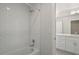 Beautiful white tiled tub and shower combination with view into bathroom at 4024 Upham St, Wheat Ridge, CO 80033