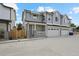 Inviting townhome exterior with a two-car garage, quaint front porch, and manicured landscaping at 4024 Upham St, Wheat Ridge, CO 80033