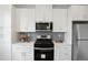 Well-lit kitchen featuring stainless steel appliances, modern white cabinetry, and sleek countertops at 4024 Upham St, Wheat Ridge, CO 80033