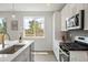 Bright modern kitchen featuring stainless steel appliances, white cabinets, and ample counter space at 4024 Upham St, Wheat Ridge, CO 80033