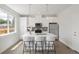 Modern white kitchen with stainless steel appliances and a center island with bar stool seating at 4024 Upham St, Wheat Ridge, CO 80033