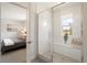 Tiled shower with window in modern bathroom with a view to the bedroom at 4024 Upham St, Wheat Ridge, CO 80033