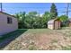 Backyard view featuring a storage shed, trees, and grass at 7391 Dale Ct, Westminster, CO 80030