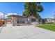 Charming single-story home with a well-manicured lawn, long concrete driveway, and an attached garage in the back at 7391 Dale Ct, Westminster, CO 80030