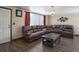 A traditional styled living room with dark leather furniture, wood flooring, and natural lighting at 7391 Dale Ct, Westminster, CO 80030
