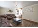 Cozy living room with dark brown leather seating, complemented by wood floors and modern lighting fixtures at 7391 Dale Ct, Westminster, CO 80030