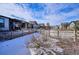 Snow-covered backyard with a wooden fence and landscaping at 7766 Fraser River Cir, Littleton, CO 80125