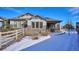 Backyard view of the house, showing a snow-covered yard and wooden fence at 7766 Fraser River Cir, Littleton, CO 80125