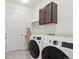 Bright laundry room, washer, dryer, cabinets, and storage at 7766 Fraser River Cir, Littleton, CO 80125