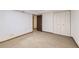 Finished basement with neutral walls and carpet, featuring closet space and a doorway to another room at 11617 W 71St Dr, Arvada, CO 80004