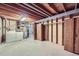 Unfinished basement with exposed beams and concrete floor, including laundry area and storage space at 11617 W 71St Dr, Arvada, CO 80004