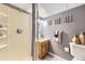 Cozy basement bathroom with shower, vanity, and gray walls, accented with decorative wall pieces at 11617 W 71St Dr, Arvada, CO 80004