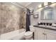 Cozy bathroom featuring a vanity, toilet, shower and tub with elegant tile surround at 11617 W 71St Dr, Arvada, CO 80004