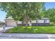 Charming home featuring a well-manicured front yard, beautiful tree, and lovely landscaping at 11617 W 71St Dr, Arvada, CO 80004