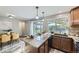 Well-lit kitchen features granite countertops, wood cabinets, an island, and backyard access at 11617 W 71St Dr, Arvada, CO 80004