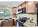 The kitchen has wood cabinets, granite countertops, stainless steel appliances, and a garden view at 11617 W 71St Dr, Arvada, CO 80004
