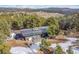 An aerial view shows the home nestled amongst mountain scenery and towering evergreen trees at 29304 Thimbleberry Ln, Evergreen, CO 80439