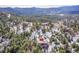 An aerial view shows the home and its location within a densely forested mountain community at 29304 Thimbleberry Ln, Evergreen, CO 80439