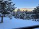 Serene backyard with snow-covered trees and stunning mountain views at 29304 Thimbleberry Ln, Evergreen, CO 80439