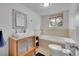 Bathroom boasts a soaking tub, single vanity, framed mirror, and a window at 29304 Thimbleberry Ln, Evergreen, CO 80439