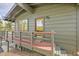 Home's charming entryway with a red deck leading to a glass-paneled door at 29304 Thimbleberry Ln, Evergreen, CO 80439