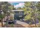 This two-story home has dark siding and a large driveway, set amongst dense evergreen trees at 29304 Thimbleberry Ln, Evergreen, CO 80439