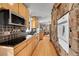 Modern kitchen with stainless steel appliances, black backsplash, wood cabinets, and a stone accent wall at 29304 Thimbleberry Ln, Evergreen, CO 80439