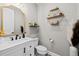 Stylish powder room features modern vanity, gold accents, and decorative shelving for a touch of elegance at 6737 S White Crow Way, Aurora, CO 80016