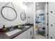 Charming bathroom featuring dual sinks, modern fixtures, and a playful dinosaur-themed shower curtain at 6737 S White Crow Way, Aurora, CO 80016