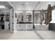 Bright bathroom featuring dual sinks, marble countertops, a soaking tub, and a walk-in closet at 6737 S White Crow Way, Aurora, CO 80016