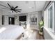 Comfortable bedroom with a ceiling fan, mounted TV, and an open view into the primary bathroom at 6737 S White Crow Way, Aurora, CO 80016