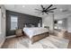 Spacious bedroom featuring an accent wall, fireplace, wood floors, and an exit to a living space at 6737 S White Crow Way, Aurora, CO 80016