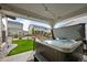 Relaxing backyard hot tub under a covered patio with string lights and views of the landscaped yard at 6737 S White Crow Way, Aurora, CO 80016