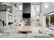 Bright living room featuring fireplace, high ceilings, many large windows, and gray sectional couch at 6737 S White Crow Way, Aurora, CO 80016