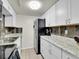 Galley kitchen with wood backsplash, stainless fridge, and updated granite countertops at 3432 S Locust St # A, Denver, CO 80222