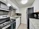 Updated kitchen features stainless steel appliances, white cabinets, and wood backsplash at 3432 S Locust St # A, Denver, CO 80222