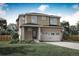 Two-story house with light brown siding, two-car garage, and landscaped lawn at 9356 Yampa Ct, Commerce City, CO 80022