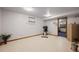 Finished basement with exercise bike, speckled flooring, and access to another room at 8223 Kincross Way, Boulder, CO 80301