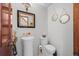 Stylish powder room with pedestal sink, decorative mirror and dark wood accents at 8223 Kincross Way, Boulder, CO 80301