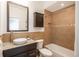 Well-maintained bathroom with tan tile, including a bathtub, toilet and vanity with a granite counter and bronze faucet at 880 E 16Th Ave # D, Denver, CO 80218