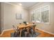 Cozy dining area with wooden table, four metal chairs, large window with shutters, and hardwood floors at 880 E 16Th Ave # D, Denver, CO 80218