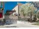 Exterior view of a home with a garage, upper level patio and a flowering tree providing natural shade at 880 E 16Th Ave # D, Denver, CO 80218