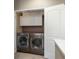 Well-organized laundry room with white cabinets above a pair of front-load washer and dryer at 880 E 16Th Ave # D, Denver, CO 80218