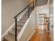 Modern stairway design with wood flooring and a sleek metal railing leading to the upper level at 880 E 16Th Ave # D, Denver, CO 80218