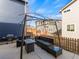 Outdoor patio with wicker seating, a glass table, grill, and a wooden fence for backyard privacy at 3155 Kedleston Ave, Highlands Ranch, CO 80126