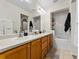 Elegant bathroom with double sink vanity, well-lit mirrors and combined tub and shower at 3155 Kedleston Ave, Highlands Ranch, CO 80126